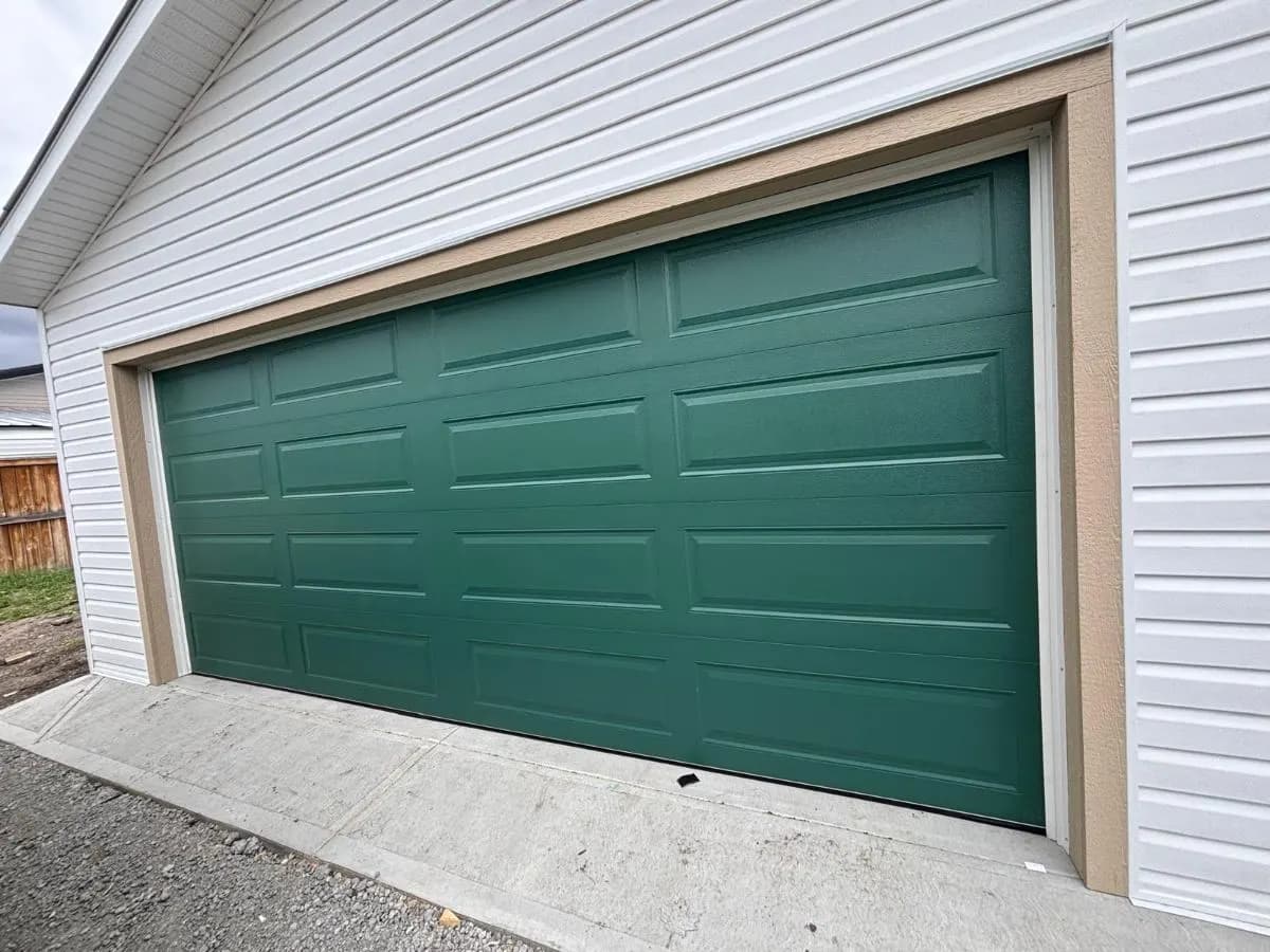 A forest-green long-panel garage door, installed by Eagle Garage Doors
