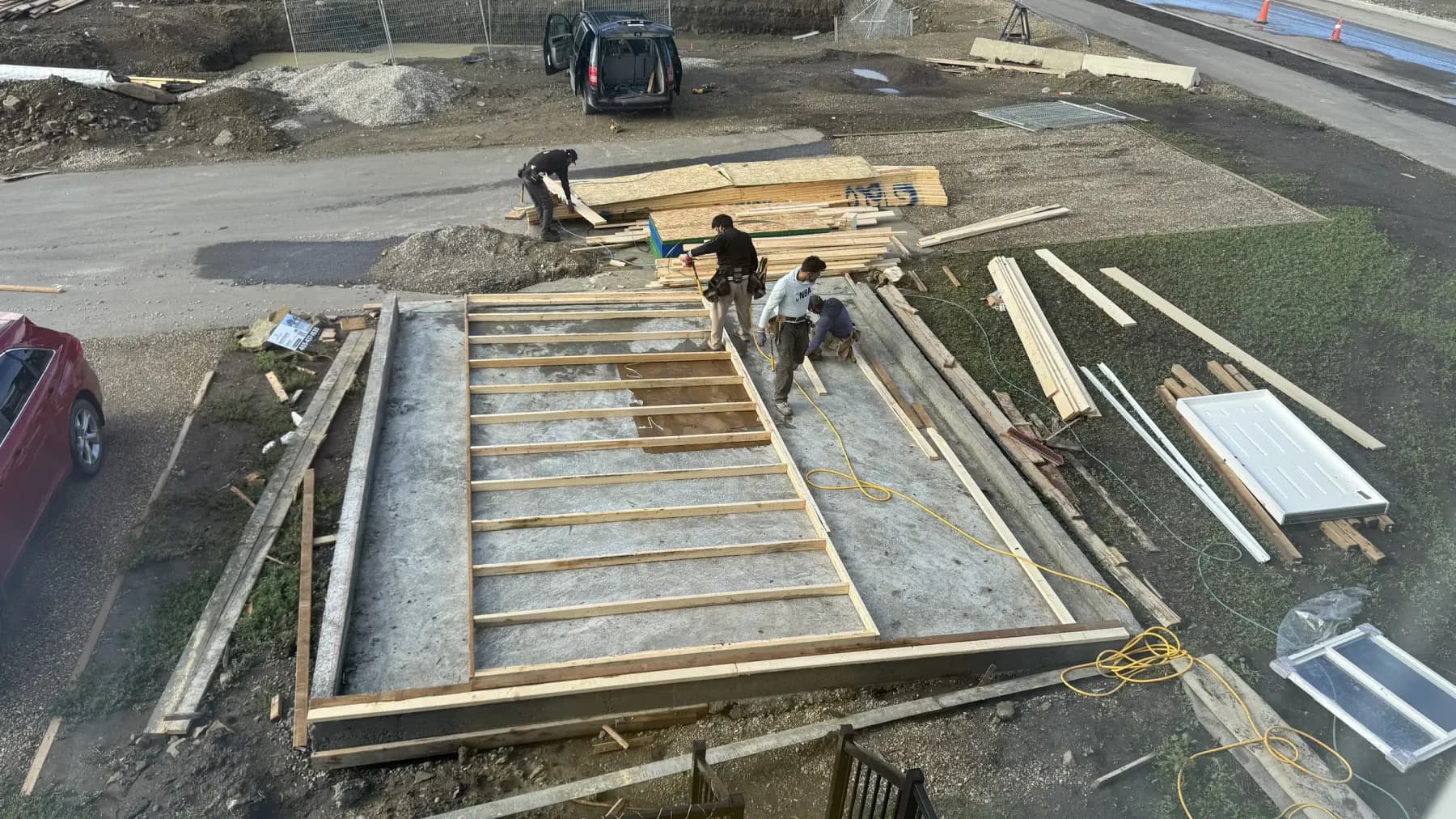 Pama Homes' crew framing a garage wall on a new slab, seen from above