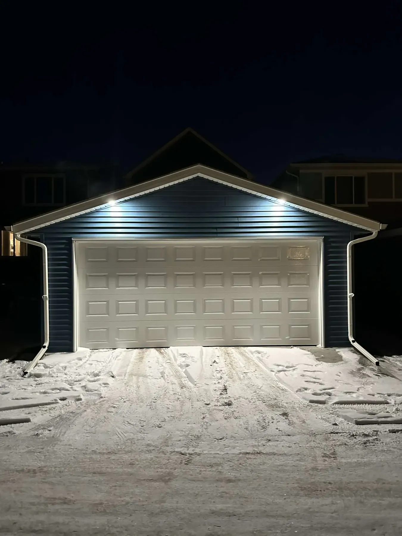 A finished double garage by Pama Homes, lit at night